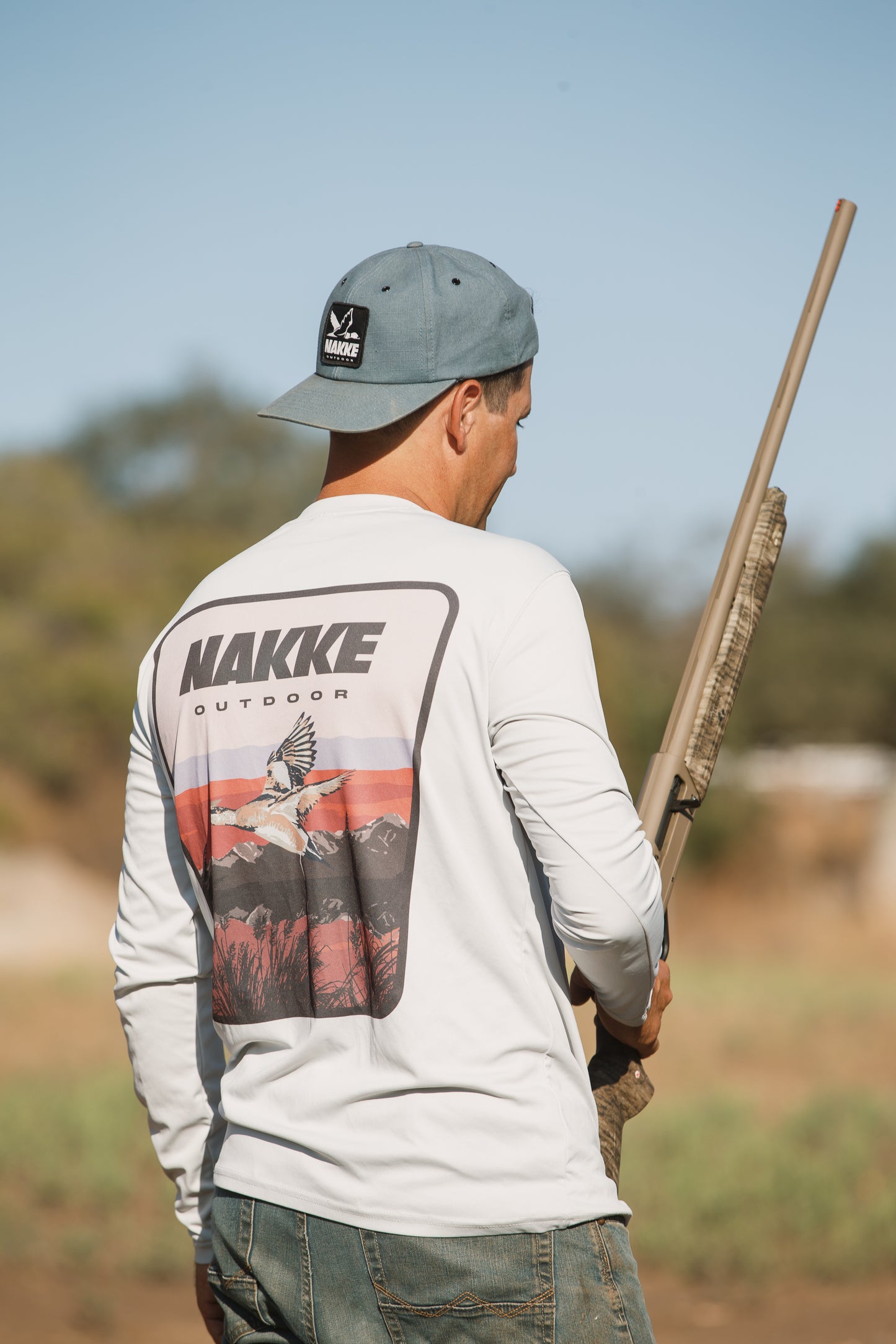 A man wearing the A Blue Outdoor Strapback Hat with the Black and White Nakke Duck Logo Patch